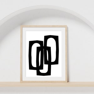 May include: Black and white abstract geometric art print in a wooden frame. The print features three overlapping shapes.