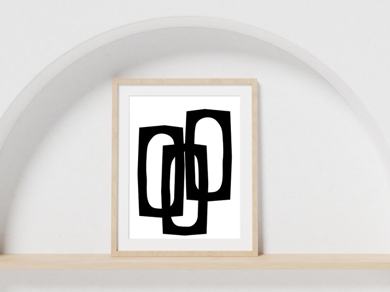 May include: Black and white abstract geometric art print in a wooden frame. The print features three overlapping shapes.