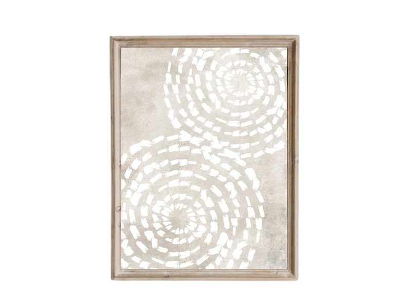 Puede incluir: Una pieza de arte de pared enmarcada con un fondo beige y dos c&iacute;rculos conc&eacute;ntricos blancos con un patr&oacute;n de espiral.