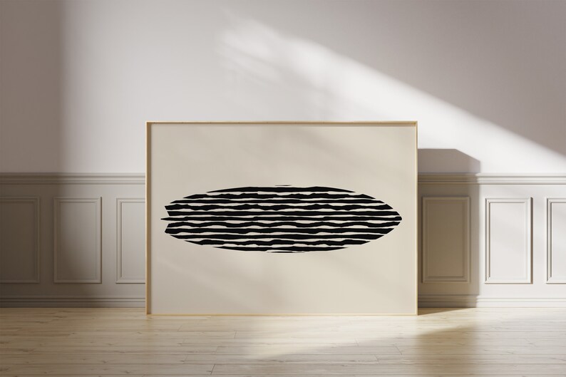 Puede incluir: Una impresi&oacute;n ovalada con rayas blancas y negras en un marco beige. La impresi&oacute;n es un dise&ntilde;o abstracto moderno.