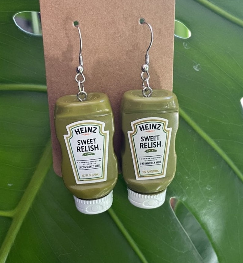 Op de afbeelding: Een paar groene Heinz Sweet Relish oorbellen. De oorbellen zijn gevormd als de iconische Heinz Sweet Relish fles. Elke oorbel heeft een zilveren haak.