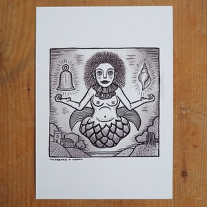 Puede incluir: Grabado en lin&oacute;leo en blanco y negro de una sirena con una campana y una concha. La sirena tiene una cola de pez y est&aacute; rodeada por un paisaje con un castillo y &aacute;rboles. El texto "THE MERMAID OF HARDEN" est&aacute; en la parte inferior.