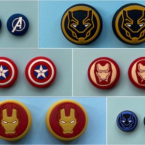 May include: Set of 10 colourful round button covers featuring Marvel superhero characters. The covers are in blue, red, yellow, and black with images of Captain America, Iron Man, and Black Panther.