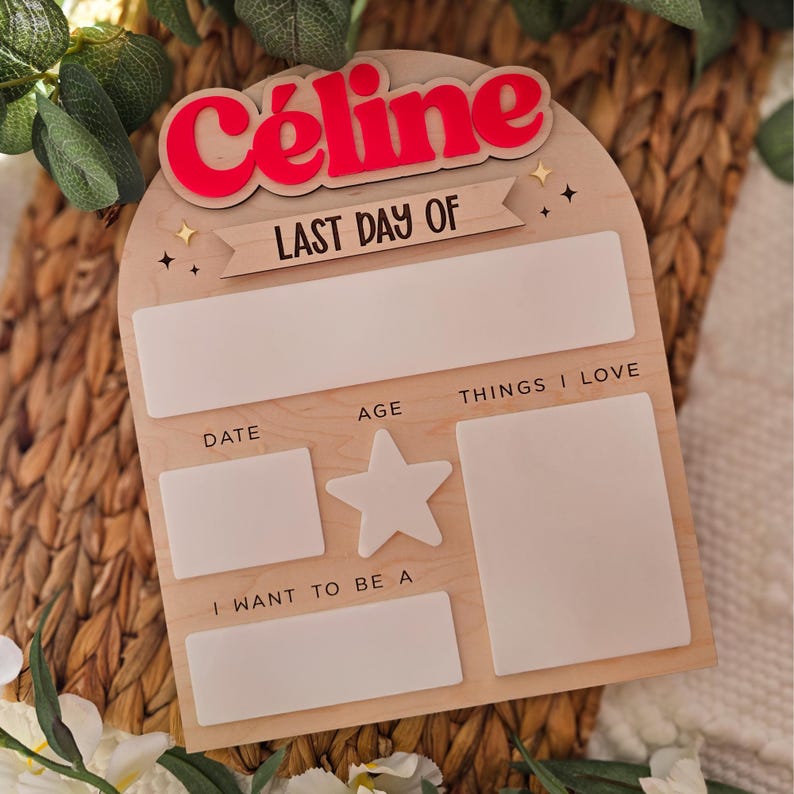 May include: Wooden sign with the name "C&eacute;line" in red, above the words "LAST DAY OF." The sign has spaces for "DATE," "AGE," "THINGS I LOVE," and "I WANT TO BE A." A star-shaped cutout is also present.