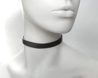 May include: A black leather choker necklace.