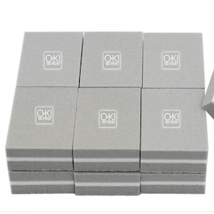 Puede incluir: Un conjunto de 9 bloques de pulido de uñas grises con bordes blancos. Cada bloque tiene impreso el texto "O-K! GEL POLISH".