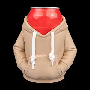 May include: A red can with a silver top is wearing a tan hoodie with white drawstrings. The hoodie has a front pocket and the can appears to be a novelty item or a decorative piece. The background is black.