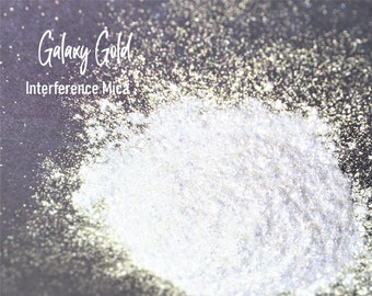 Peut inclure: Gros plan sur un tas de poudre de mica d'interférence Galaxy Gold. La poudre est de couleur blanche irisée claire avec un léger reflet doré.