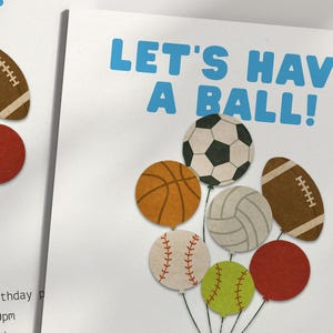 May include: A white invitation with the text "LET'S HAVE A BALL!" in blue. The invitation features illustrations of various sports balls, including a soccer ball, basketball, baseball, volleyball, football, and softball.
