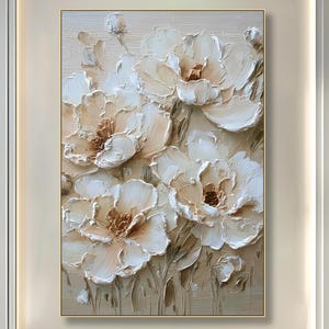 Pode incluir: Uma grande pintura floral emoldurada com um efeito texturizado tridimensional. A obra apresenta grandes flores creme com centros castanhos sobre um fundo neutro. A pintura está pendurada acima de um sofá branco em uma sala de estar moderna.