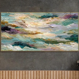 May include: Abstract oil painting on canvas, featuring a textured cloudscape in shades of teal, yellow, purple, and white. The artwork is framed in a gold-colored border, creating a striking visual contrast. The painting is a large rectangular piece.