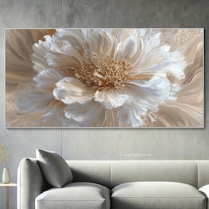 May include: A large, rectangular canvas art piece featuring a detailed, textured depiction of a flower. The artwork uses a palette of creamy white, beige, and gold tones. The flower's petals are prominently displayed, with a central, textured core. The piece is framed in a simple, neutral-toned border.