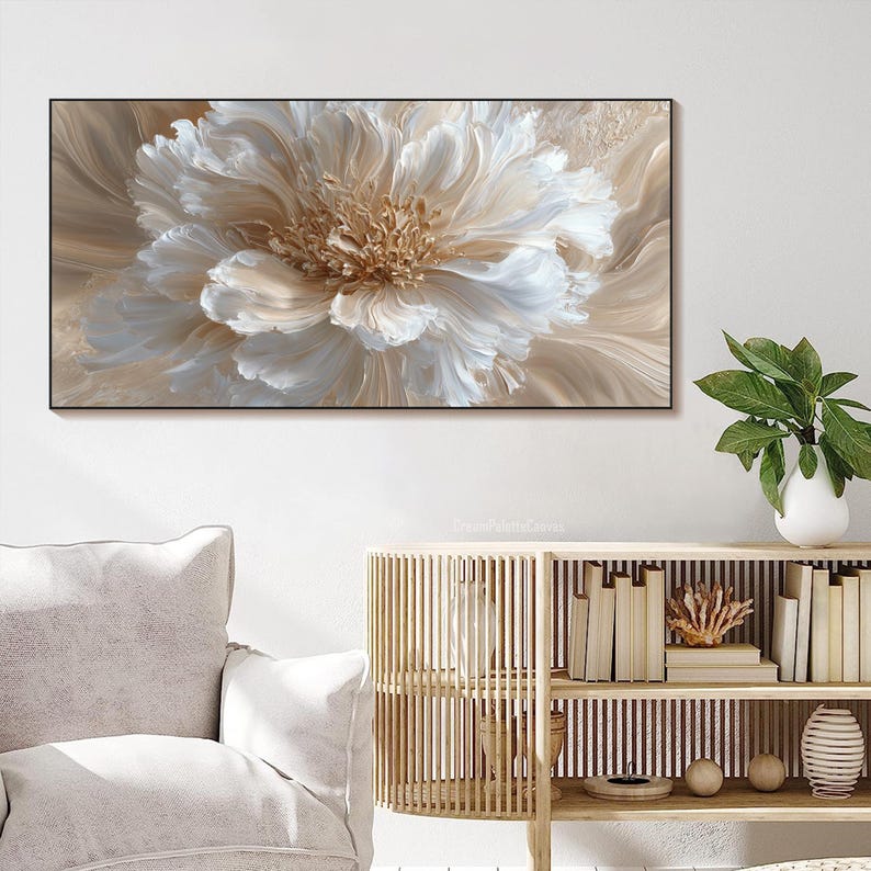 May include: A large, rectangular canvas print featuring a close-up of a cream-colored flower with detailed petals. The flower's center is a warm, golden hue, and the background has soft, beige tones. The artwork is framed in black.