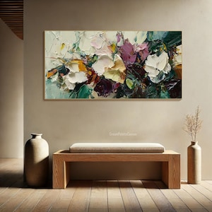 May include: Abstract painting with a colorful floral design. The painting features shades of white, pink, purple, green, and yellow. The paint is applied in thick strokes, creating a textured effect.