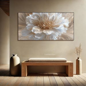 May include: A large, rectangular canvas art piece featuring a close-up of a cream-colored flower with textured petals. The artwork is framed in black and hangs above a wooden bench. The room is decorated in neutral tones.