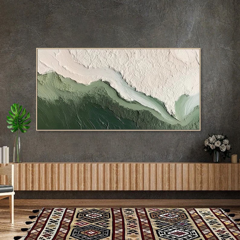 May include: Abstract painting with a white and green color scheme. The painting features a textured, layered effect, creating a sense of depth and movement. The painting is framed in a thin, wooden frame.
