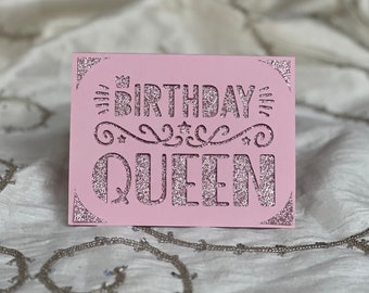 May include: Pink card with glitter lettering that says "Birthday Queen".
