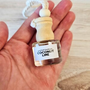 A car diffuser in the palm of a hand, for scale. Diffusers are approximately 1.75 inches tall, 1 inch wide. They hold roughly 0.2 ounces of fragrance oil. Cord is 6 inches long for hanging from rearview mirror.