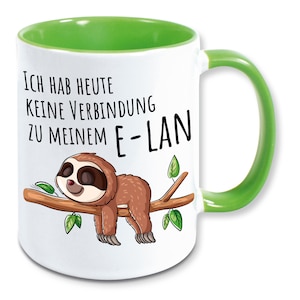 Könnte beinhalten: Weiße Keramiktasse mit grünem Rand und Henkel. Die Tasse zeigt einen schlafenden Cartoon-Faultier auf einem Ast mit dem Text "Ich hab heute keine Verbindung zu meinem E-LAN".