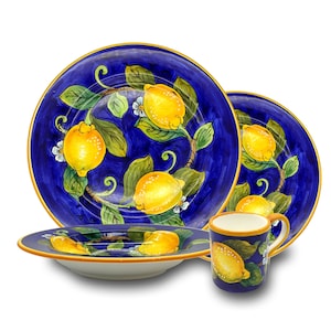 Peut inclure: Un ensemble de vaisselle en céramique bleue et jaune avec un motif de citron. L'ensemble comprend une grande assiette, une assiette plus petite et une tasse.