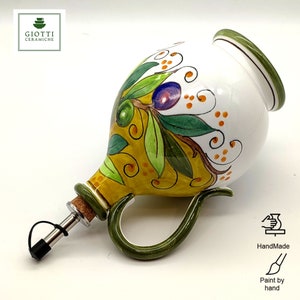 May include: White ceramic olive oil bottle with a green handle and a cork stopper. The bottle is decorated with a hand-painted olive branch design in shades of green, yellow, and orange.