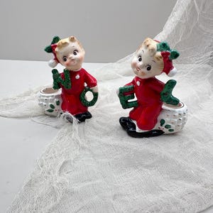 Puede incluir: Una taza de cerámica blanca con un asa negra y el texto "But First, Coffee" en negrita negra. La taza está sobre una superficie de madera. La taza mide aproximadamente 10 cm de alto.