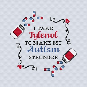 以下が含まれることがあります： 「I take Tylenol to make my Autism stronger」の文字が入ったクロスステッチのデザイン。赤、白、青のピルボトルと散らばったピルが描かれています。装飾要素にはハートと渦巻きがあり、すべて水色の背景に配置されています。