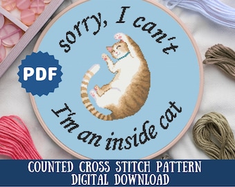 May include: A counted cross stitch pattern featuring a cartoon cat with the text "sorry, I can't I'm an inside cat". The pattern is on a blue background and is available as a digital download.