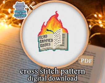 May include: A cross-stitch pattern featuring a burning book with the text "READ BANNED BOOKS." The design is set in a wooden embroidery hoop. The image includes the text "cross stitch pattern digital download."
