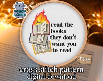 May include: A cross-stitch pattern in a wooden hoop features the text "read the books they don't want you to read" with pixelated books and flames. The words "cross stitch pattern digital download" are below.