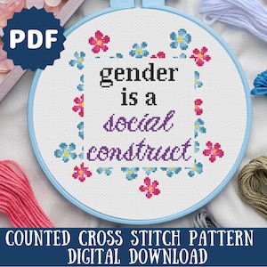 May include: A counted cross stitch pattern PDF download for a design that says "gender is a social construct" surrounded by blue and pink flowers.