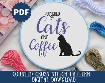 May include: A counted cross stitch pattern featuring a black cat silhouette and the text "Powered by Cats and Coffee". The pattern is displayed on a blue embroidery hoop and surrounded by colorful embroidery floss.