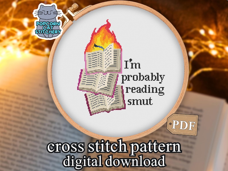 May include: Cross stitch pattern featuring a design of burning books with the text "I'm probably reading smut." The design is set in a wooden embroidery hoop. The words "cross stitch pattern digital download" are also included.