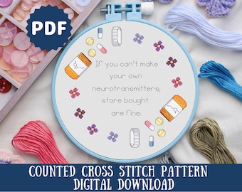 May include: A counted cross stitch pattern for a funny quote about neurotransmitters. The pattern is on a white background with blue and purple flowers and pills. The quote reads "If you can't make your own neurotransmitters, store bought are fine."