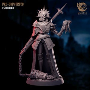 Może przedstawiać: Szczegółowa, szara miniaturowa figurka szkieletowego wojownika, trzymającego łańcuch i odciętą głowę. Figurka jest ubrana w bogatą zbroję i długi płaszcz, z koroną z kolców. Podstawa ma 25 mm. Tekst brzmi "PRE-SUPPORTED 25mm BASE".