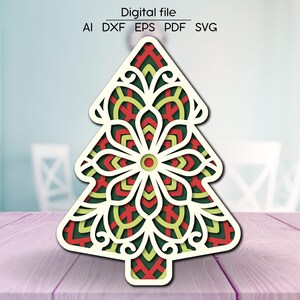 May include: A white Christmas tree cutout with a red, green, and yellow mandala design. The tree is decorated with intricate details and is perfect for laser cutting or crafting.
