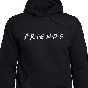 Op de afbeelding: Zwart hoodie met het woord "FRIENDS" in witte letters met gekleurde stippen.