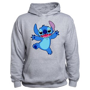 Puede incluir: Una sudadera con capucha gris con un personaje de dibujos animados azul de Stitch de Lilo & Stitch. Stitch est&aacute; sonriendo y tiene los brazos extendidos.