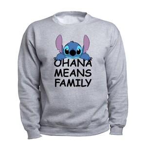 Pode incluir: Camisola de cor cinzenta com um personagem Stitch azul a espreitar por cima. O texto "Ohana means family" est&aacute; impresso abaixo do personagem.