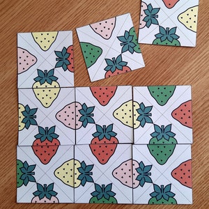 May include: Nine square tiles with a white background and a repeating pattern of green, pink, and yellow strawberries. Each tile has a white grid pattern with diagonal lines.