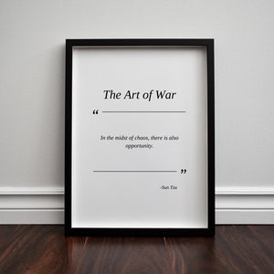 May include: A black framed print with a white background and the text "The Art of War" in black. The quote "In the midst of chaos, there is also opportunity." is printed below the title, followed by the author's name, "Sun Tzu".