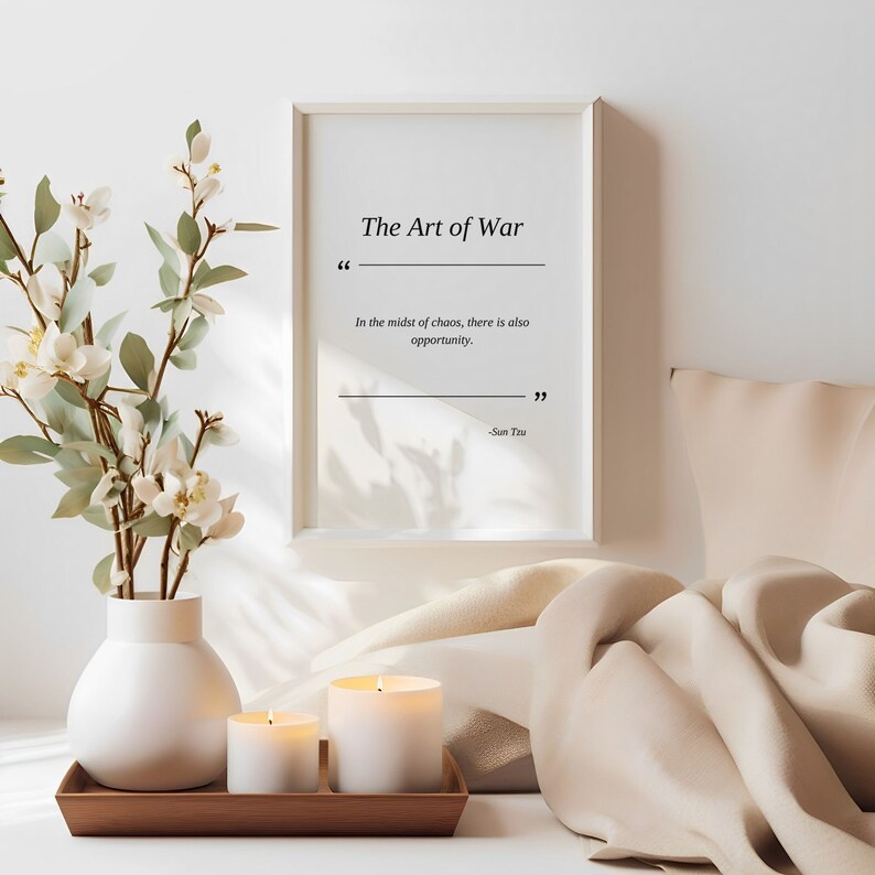 May include: A white framed print with the text "The Art of War" and a quote from Sun Tzu: "In the midst of chaos, there is also opportunity."