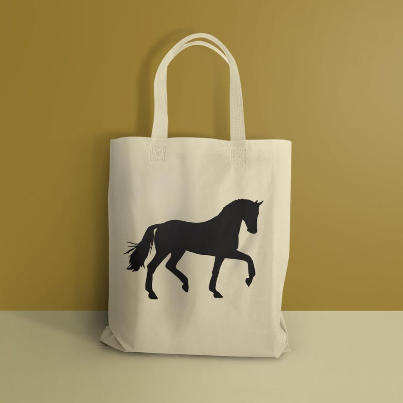 May include: A cream-colored canvas tote bag featuring a solid black silhouette of a horse in a trotting pose. The bag has two matching fabric handles attached to the top, providing a simple and functional design for carrying various items.