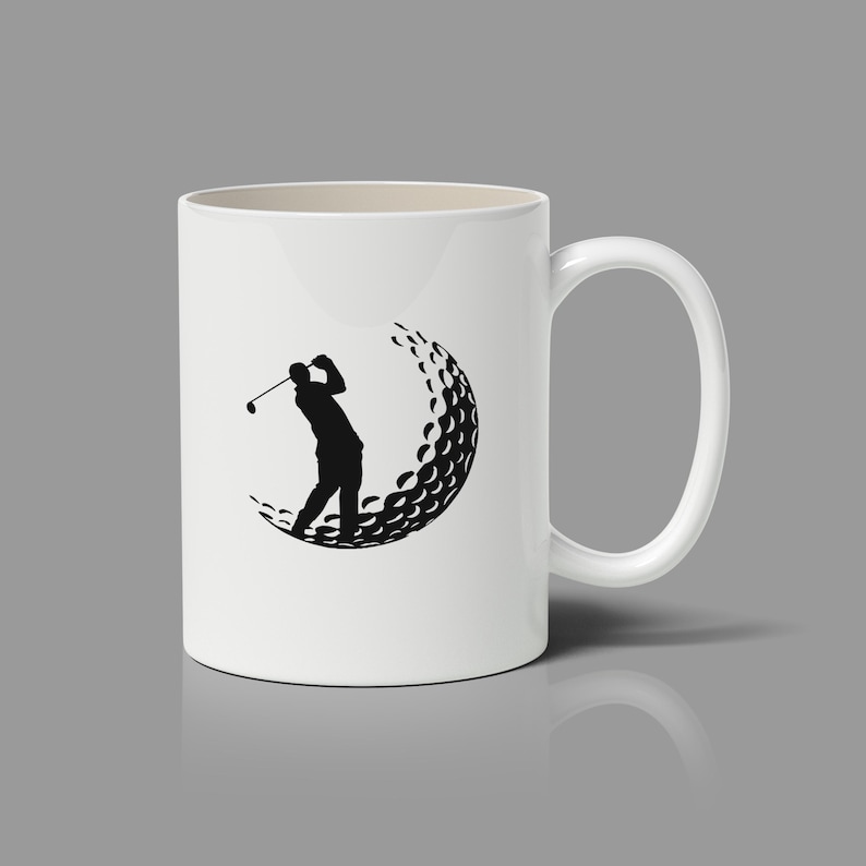 May include: White ceramic coffee mug with a black silhouette of a golfer swinging a club inside a golf ball graphic.