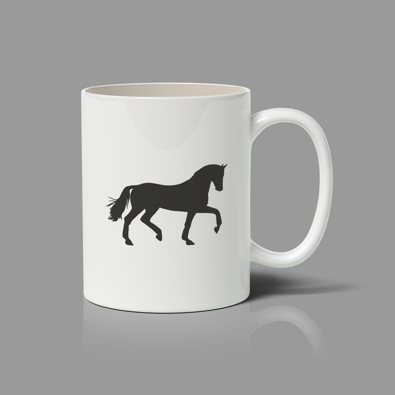 May include: A white ceramic mug featuring a black silhouette of a horse in a trotting stance. The mug has a smooth, cylindrical body with a curved handle on the right side. The design is centered on the front of the mug, showcasing the horse.