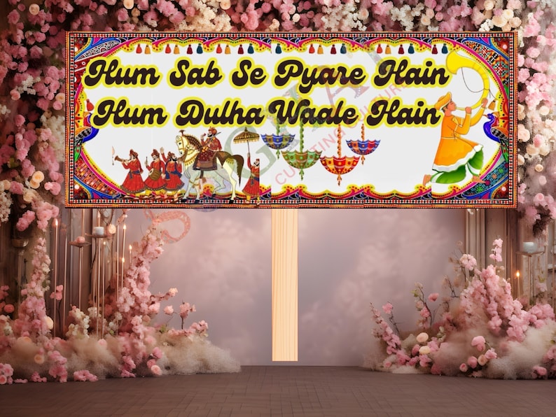 May include: A decorative sign with the text "Hum Sab Se Pyare Hain Hum Dulha Waale Hain" in yellow and black. The sign features illustrations of people, horses, and umbrellas, with a colorful border. The background is a floral arrangement.