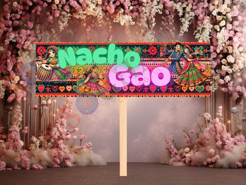 May include: A decorative sign with the words "Nacho Gao" in green and pink, featuring colorful illustrations of Indian dancers and musicians. The sign is mounted on a wooden stick, suitable for celebrations.