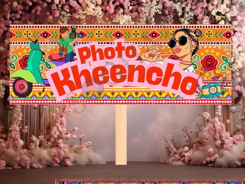 May include: A decorative sign with the text "Photo Kheecho" in red, featuring illustrations of a scooter, a woman with sunglasses, and a photographer. The sign has a colorful, patterned border and is mounted on a wooden post.