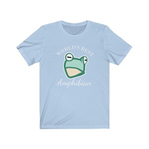 May include: Light blue t-shirt with a white graphic of a frog and the text "World's Best Amphibian".