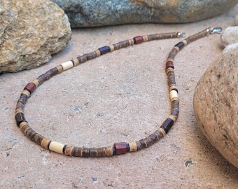 May include: A brown, white, and red wooden beaded necklace with a silver clasp.